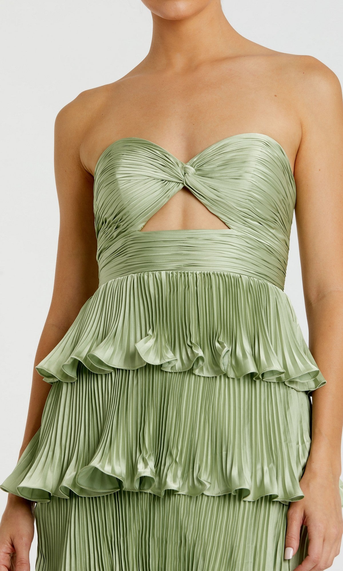 Someone in the Mac Duggal 49981 Long Formal Dress—a strapless, light green pleated gown featuring a twisted bodice, cutout accents, and tiered ruffled layers reminiscent of a column silhouette.